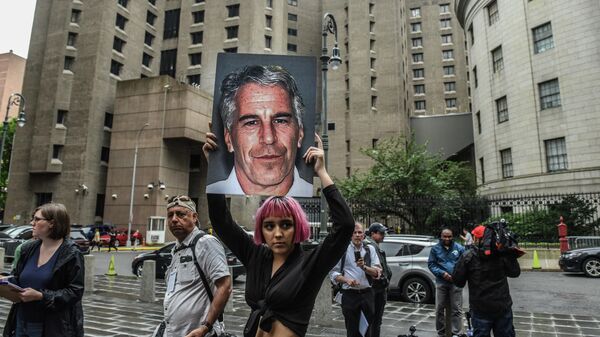 A member of a protest group called Hot Mess holds up a sign of Jeffrey Epstein in front of the Metropolitan Correction Center on July 8, 2019 in New York City. - Sputnik International