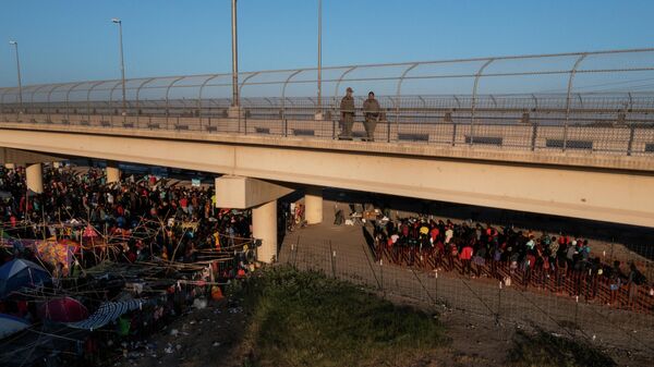 Texas State Troopers walk across the International Bridge as some migrants line up to depart on a bus as thousands of others await to be processed after crossing the Rio Grande river into the U.S. from Ciudad Acuna in Del Rio, Texas, U.S. September 20, 2021 - Sputnik International