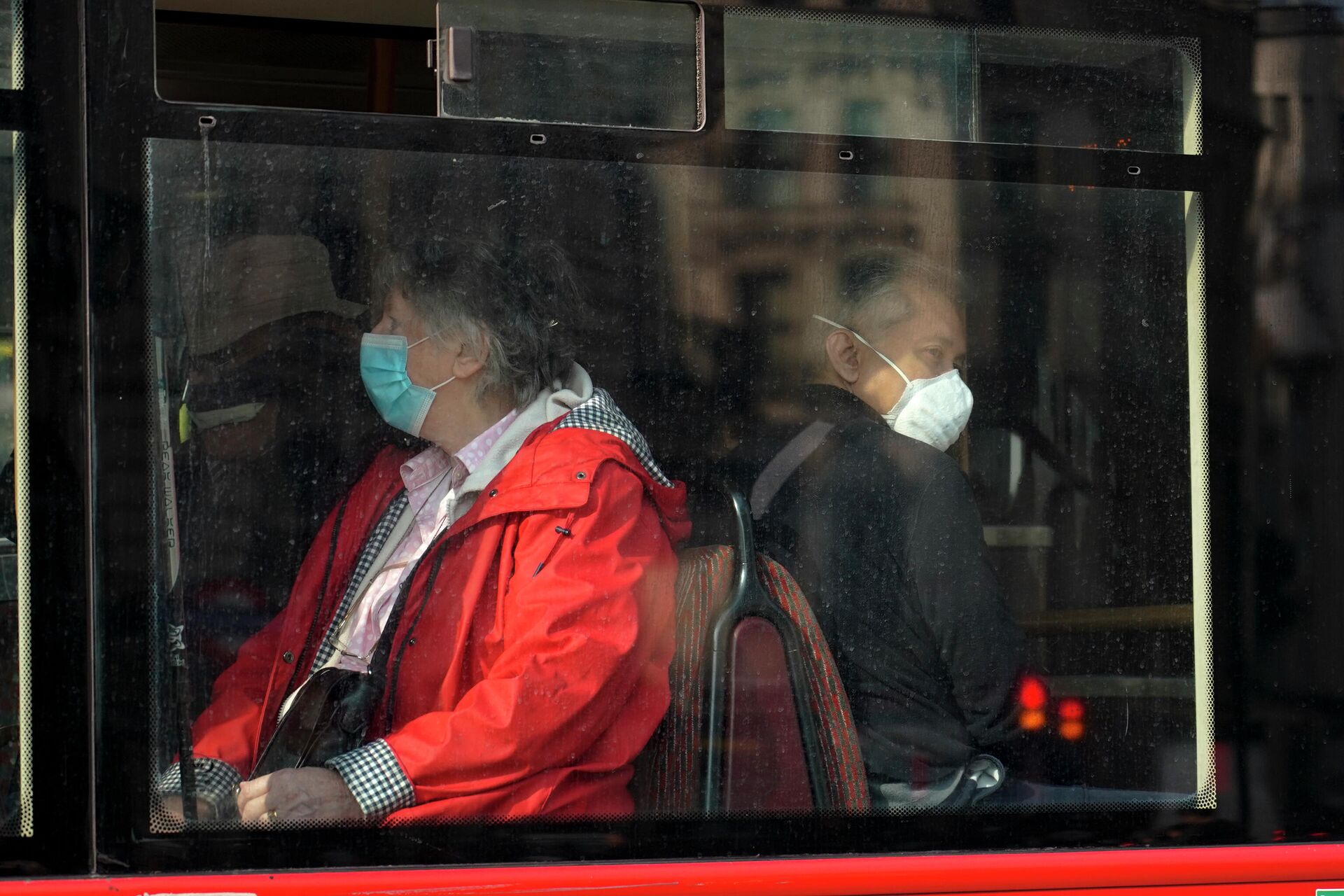 People wear face masks as they sit on a bus, in London, Tuesday, Oct. 19, 2021. - Sputnik International, 1920, 21.10.2021