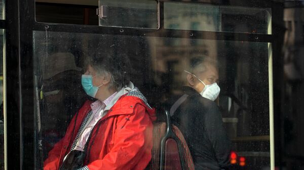 People wear face masks as they sit on a bus, in London, Tuesday, Oct. 19, 2021. - Sputnik International