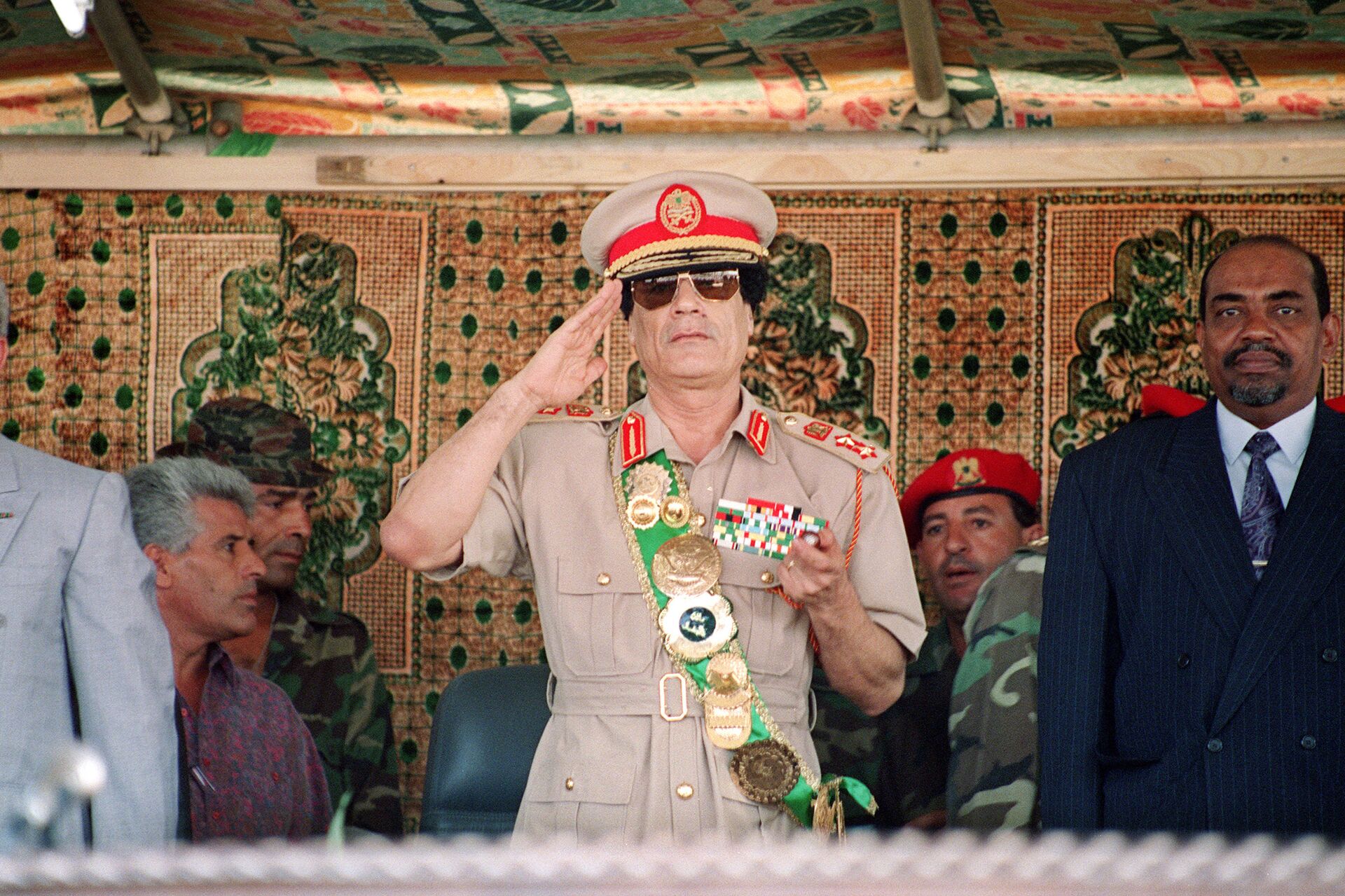 Libyan leader colonel Muammar Gaddafi (C), salutes troops during a military parade on 1 September 1994 in Tripoli for the celebration of the 25th anniversary of his arrival in power.  - Sputnik International, 1920, 16.11.2021