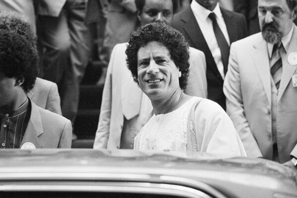 Libyan leader Muammar Gaddafi smiles to photographers as he leaves the African Hall during the second day of a pre-Summit Committee meeting at the 19th Summit of the Organisation of African Unity in Addis Ababa, 7 June 1983. - Sputnik International