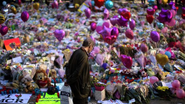 A man stands next to flowers for the victims of Monday's bombing at St Ann's Square in central Manchester, England, Friday, May 26 2017.  - Sputnik International