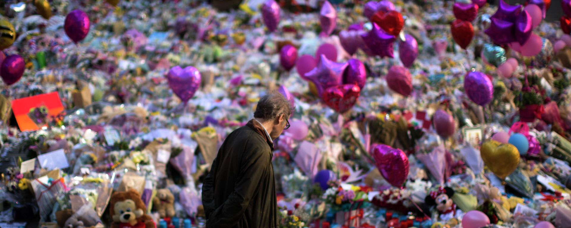 A man stands next to flowers for the victims of Monday's bombing at St Ann's Square in central Manchester, England, Friday, May 26 2017.  - Sputnik International, 1920, 21.10.2021