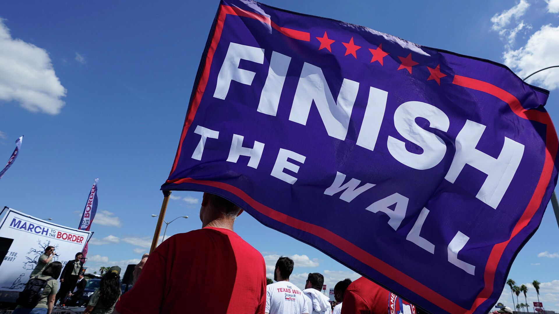 A participant holds a Finish The Wall flag at a March to the Border Rally, Saturday, Sept. 25, 2021, in McAllen, Texas. - Sputnik International, 1920, 22.10.2021