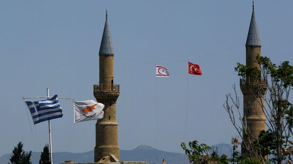 Greek, left, and Cyprus' flags, second left, flutter on poles in the south, as in the north Turkish occupied area, a Turkish and Turkish Cypriot breakaway flags fly on a minaret of the Selimiye mosque, or Cathedral of St Sophia, or Agia Sofia, in divided capital Nicosia, Cyprus, Monday, April 26, 2021 - Sputnik International