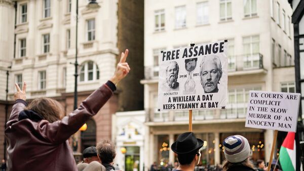 Supporters of WikiLeaks founder Julian Assange hold placards as they gather outside the Royal Courts of Justice, in London, Saturday, Oct. 23, 2021, ahead of next week's extradition case appeal.  - Sputnik International