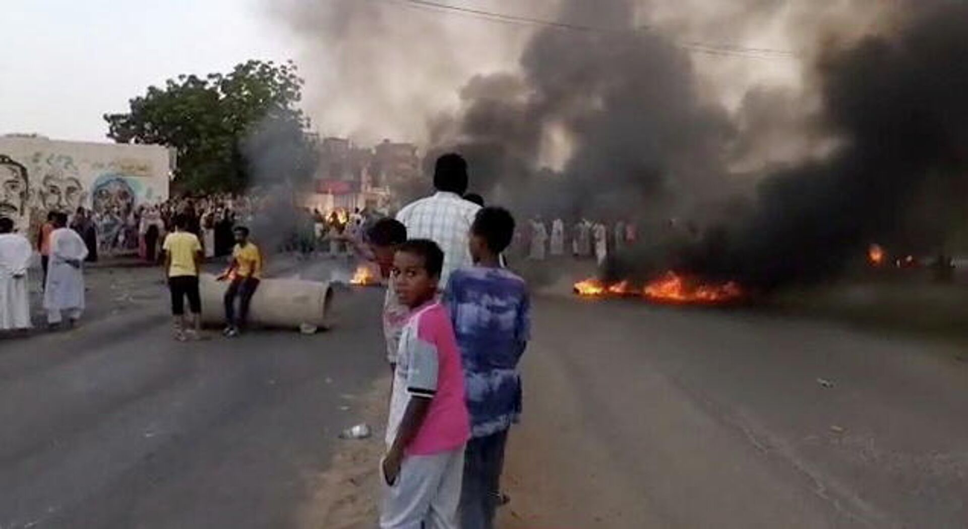 People gather around as smoke and fire are seen on the streets of Khartoum, Sudan, amid reports of a coup, 25 October 2021, in this still image from video obtained via social media. - Sputnik International, 1920, 03.11.2021