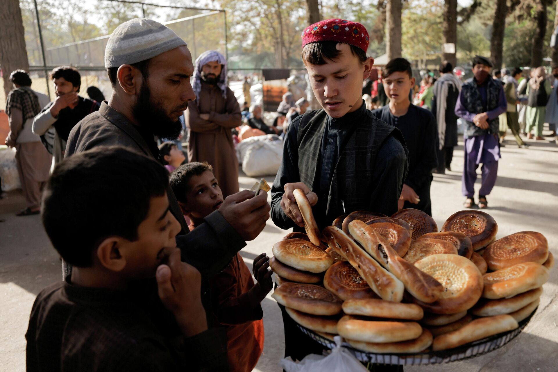 A boy sells bread at a makeshift shelter for displaced Afghan families, who are fleeing the violence in their provinces, at Shahr-e Naw park, in Kabul, Afghanistan October 4, 2021. - Sputnik International, 1920, 25.10.2021