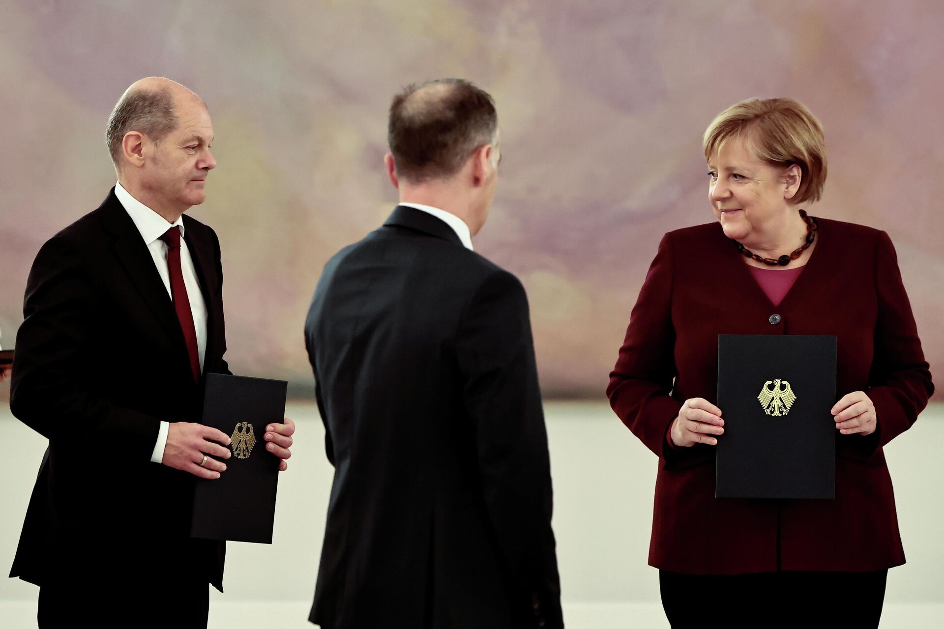 Social Democratic Party (SPD) candidate for Chancellor Olaf Scholz and Germany's acting Chancellor Angela Merkel hold their 'discharge certificates' at the Bellevue Palace in Berlin, Germany, October 26, 2021. REUTERS/Hannibal Hanschke - Sputnik International, 1920, 26.10.2021