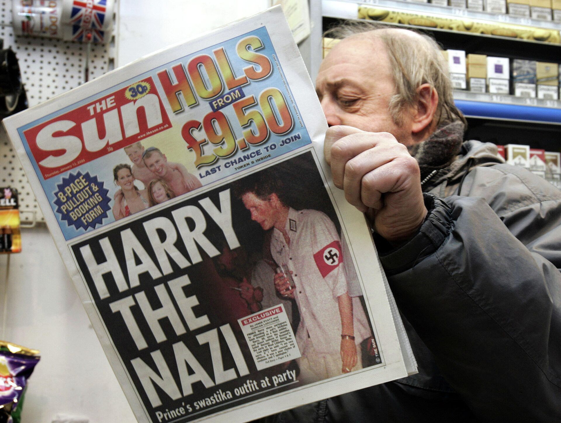 News agent Roy Ottoway reads a copy of tabloid 'The Sun', whose front page shows a picture of Britain's Prince Harry wearing a Nazi soldier's uniform to a fancy dress party, early Thursday morning, Jan. 13, 2005 at King's Cross station in London.  - Sputnik International, 1920, 27.10.2021