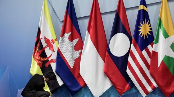 In this Nov. 13, 2018, file photo, a worker adjusts the Brunei Darussalam flag prior the 22nd ASEAN coordinating council meeting on the sidelines of the 33rd ASEAN summit in Singapore. China is hosting foreign ministers from 10 Southeast Asian nations amid heightened competition between Beijing and Washington for influence in the region. - Sputnik International