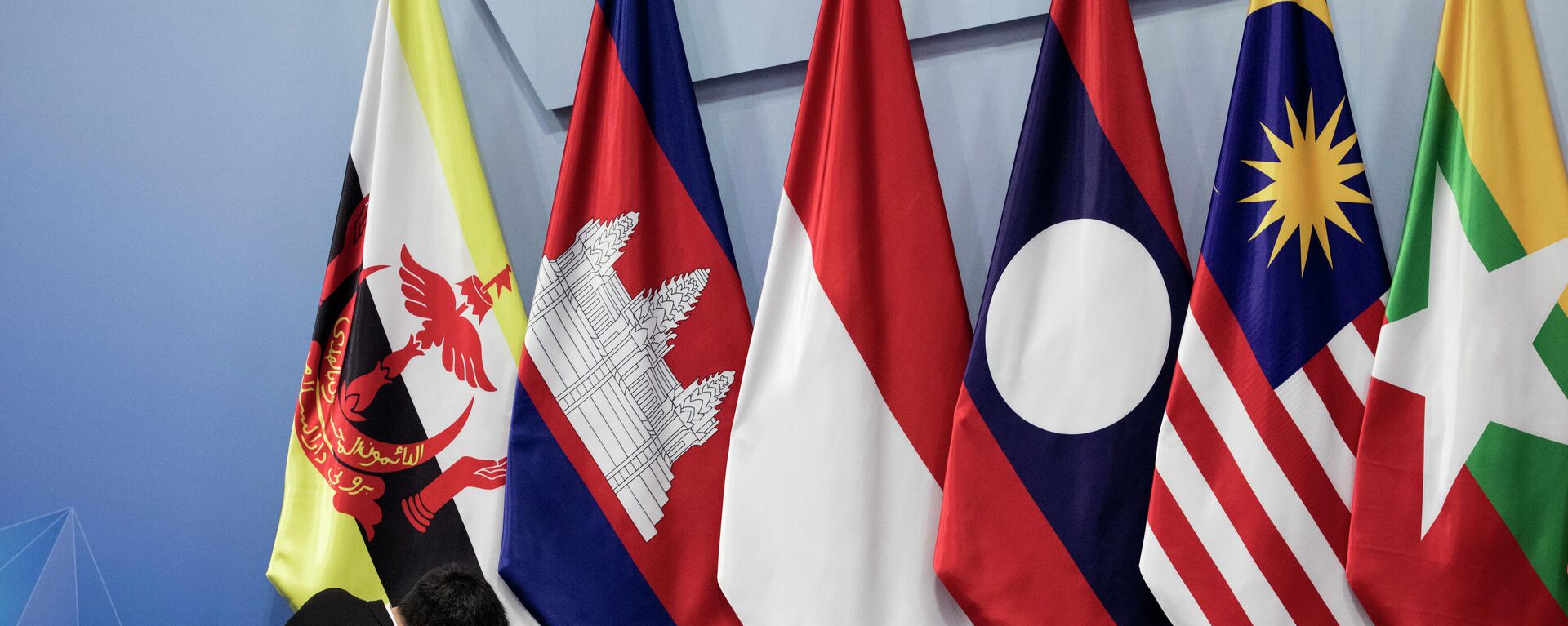 In this Nov. 13, 2018, file photo, a worker adjusts the Brunei Darussalam flag prior the 22nd ASEAN coordinating council meeting on the sidelines of the 33rd ASEAN summit in Singapore. China is hosting foreign ministers from 10 Southeast Asian nations amid heightened competition between Beijing and Washington for influence in the region. - Sputnik International, 1920, 25.10.2022