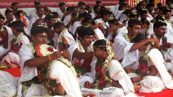 Indian grooms tie mangalsutra around the necks of their brides during a mass marriage in Hyderabad, India, Saturday, Aug. 14, 2010 - Sputnik International