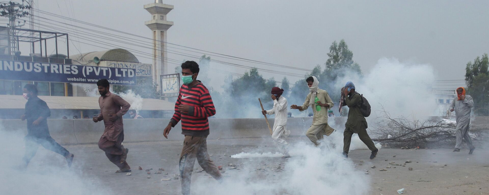 Supporters of the banned Islamist political party Tehrik-e-Labaik Pakistan (TLP) run amid the smoke of tear gas during a protest demanding the release of their leader and the expulsion of the French ambassador over cartoons depicting the Prophet Mohammed, in Lahore, Pakistan, October 23, 2021 - Sputnik International, 1920, 28.10.2021