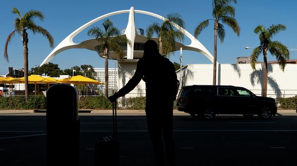 In this Nov. 25, 2020, file photo, a traveler awaits for transportation at the Los Angeles International Airport in Los Angeles. - Sputnik International