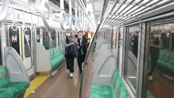 People run away through a carriage of a Tokyo train line following a knife, arson and acid attack, in Tokyo, Japan October 31, 2021 in this still image obtained from a social media video.  - Sputnik International