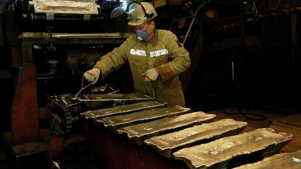 A worker controls forming of aluminium ingots on a conveyor belt at the foundry shop of the Rusal Krasnoyarsk aluminium smelter in Krasnoyarsk, Russia - Sputnik International
