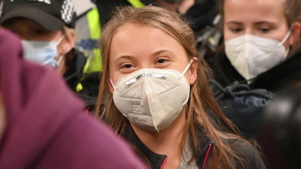 Wearing a face mask as protection against covid-19, Swedish climate activist Greta Thunberg arrives at Central station in Glasgow, Scotland on October 30, 2021, ahead of the COP26 UN Climate Change Conference to be held in the city from October 31. - Sputnik International
