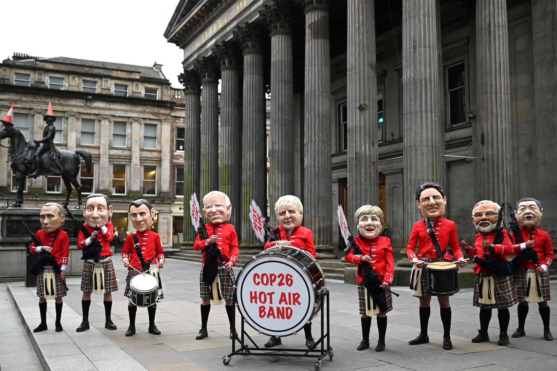 Oxfam activists dressed as a Scottish pipe band and representing (L-R) Russian President Vladimir Putin, Italian Prime Minister Mario Draghi, French President Emmanuel Macron, US President Joe Biden, British Prime Minister Boris Johnson, Germany's Chancellor Angela Merkel, Canadian Prime Minister Justin Trudeau, India's Prime Minister Narendra Modi and Chinese President Xi Jinping pose during their Big Heads protest stunt at the Royal Exchange Square in Glasgow on November 1, 2021 on the sidelines of the COP26 UN Climate Summit.  - Sputnik International, 1920, 01.11.2021