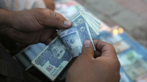 In this Monday, Dec. 5, 2016 photo, an Afghan money changer counts Pakistani currency banknotes at a money exchange market in Kabul, Afghanistan. - Sputnik International