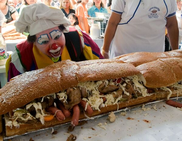 A clown gazes at a 46-metre &#x27;torta&#x27; (Mexican sandwich) during the annual &#x27;Torta Festival&#x27; in Mexico City, on 31 July 2009. More than 200 people helped to make the giant sandwich, which includes meat, avocado, mole (Mexican spicy sauce), turkey, tomatoes, beans, ham and different types of cheese as they attempt to break the record for the longest &#x27;torta&#x27;. - Sputnik International