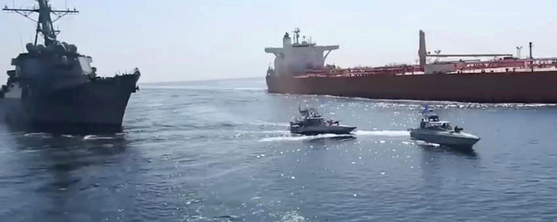 This frame grab from a video released by Iran's paramilitary Revolutionary Guard on Wednesday, Nov. 3, 2021, shows the Guard speed boats, center, in front of a U.S warship, left, amid the seizure of a Vietnamese-flagged oil tanker, right, in the Gulf of Oman. Iran seized the tanker in the Gulf of Oman last month and still holds the vessel, two U.S. officials told The Associated Press on Wednesday, revealing the latest provocation in Mideast waters as tensions escalate between Iran and the United States over Tehran's nuclear program. (Revolutionary Guard via AP) - Sputnik International, 1920, 04.11.2021