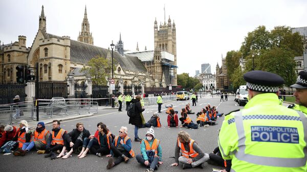 Insulate Britain activists have their hands and feet glued to the road as they block a road outside the Houses of Parliament during a protest in London, Britain on 4 November 2021. - Sputnik International