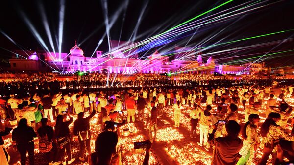 People watch a laser show on the banks of the river Sarayu during Deepotsav celebrations on the eve of the Hindu festival of Diwali in Ayodhya on November 3, 2021. (Photo by SANJAY KANOJIA / AFP) - Sputnik International