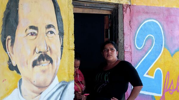 A woman sits next to an image of Nicaragua's president, Daniel Ortega in Catarina, Nicaragua October 1, 2020. - Sputnik International