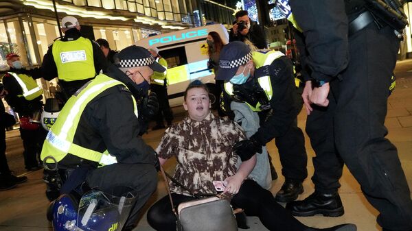 An anti-capitalist demonstrator is taken away by police officers on Oxford Street during the 'Million Mask March', organised by the group Anonymous, in London on 5 November. Activists gather for a march in the centre of London on Britain's Guy Fawkes Night with many wearing white masks of the man who was caught plotting to blow up parliament in 1605, now associated with the group Anonymous, Guido (Guy) Fawkes. - Sputnik International