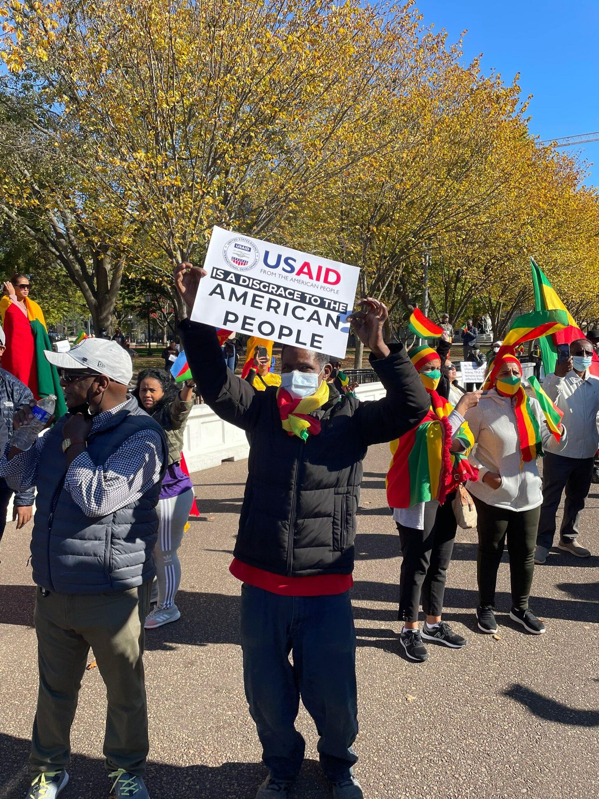 A protester at a pro-Ethiopian government rally outside the White House in Washington, DC, on November 8, 2021, holds a sign saying USAID is a Disgrace to the American People. - Sputnik International, 1920, 22.11.2021
