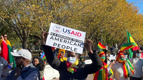 A protester at a pro-Ethiopian government rally outside the White House in Washington, DC, on November 8, 2021, holds a sign saying USAID is a Disgrace to the American People. - Sputnik International