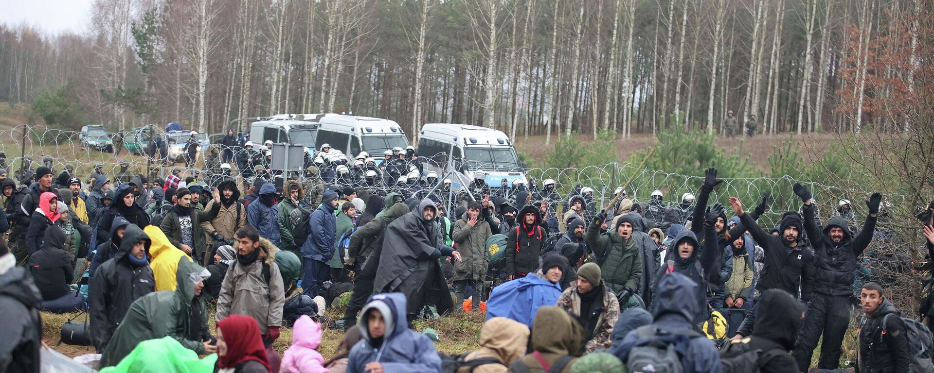 Migrants gather near a barbed wire fence in an attempt to cross the border with Poland in the Grodno region, Belarus November 8, 2021 - Sputnik International, 1920, 16.11.2021