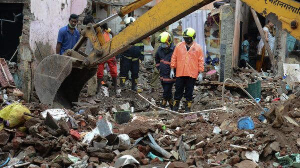 Civil authority and rescue personnel search for survivors in the debris of a building that collapsed following heavy monsoon rains, in Mumbai on June 10, 2021 - Sputnik International