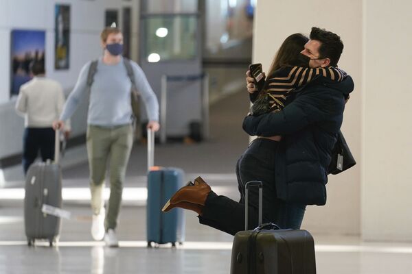 Natalia Abrahao is lifted up by her fiancé Mark Ogertsehnig as they greet one another at Newark Liberty International Airport in Newark, NJ, Monday 8 November 2021. Pandemic travel restrictions have made their recent meetings difficult and infrequent.  - Sputnik International