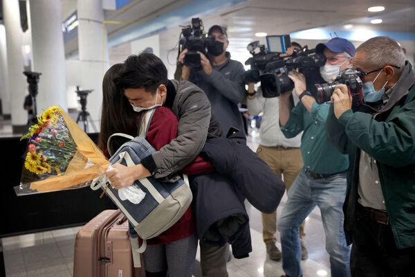 News crews gather around as Yerin Hong gets a hug from her boyfriend Soomin Kim after she arrived on a flight from Germany at the international terminal at O&#x27;Hare International Airport on 8 November 2021 in Chicago, Illinois.  - Sputnik International