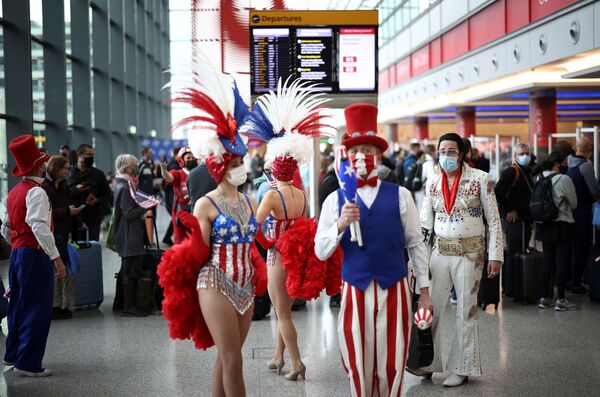 Performers engage with travellers as they queue to check into Virgin Atlantic and Delta Air Lines flights at Heathrow Airport Terminal 3, following the lifting of restrictions on the entry of non-US citizens to the United States imposed to curb the spread of the coronavirus disease (COVID-19), in London, Britain, 8 November 2021. - Sputnik International