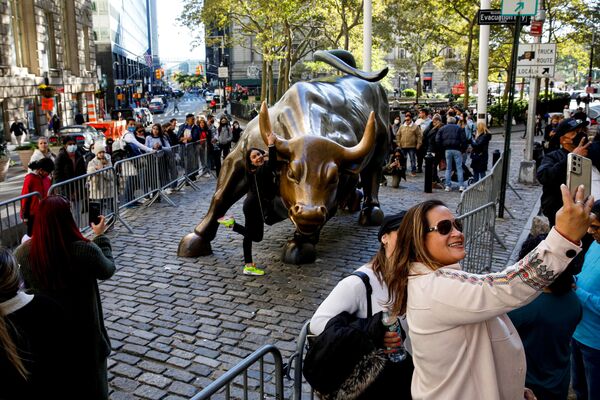 Tourists gather around the Charging Bull statue, also known as the Wall St. Bull, following the lifting of restrictions on the entry of non-US citizens imposed to help curb the spread of the coronavirus disease (COVID-19), in New York, US, 8 November 2021. - Sputnik International