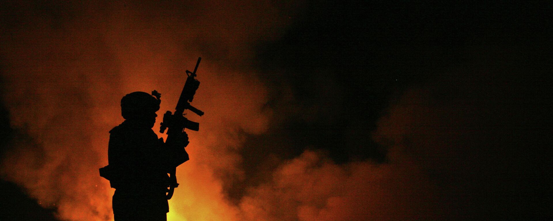 Sgt. Robert B. Brown from Fayetteville, N.C. with Regimental Combat Team 6, Combat Camera Unit watches over the civilian Fire Fighters at the burn pit as smoke and flames rise into the night sky behind him on May 25th, 2007. - Sputnik International, 1920, 20.03.2022