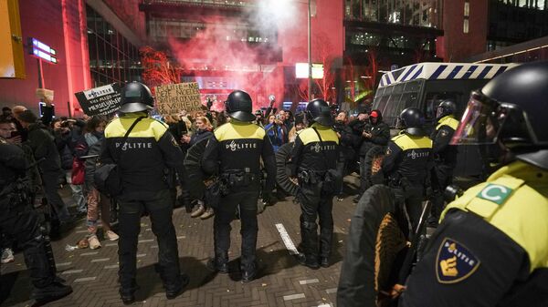 Riot police officers face protesters as they gather in the Hague, on November 12, 2021, during a press conference of Dutch Prime Minister held to announce new Covid-19 restrictions - Sputnik International