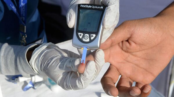 An Indian nurse (L) collects a blood sample from a policeman using a glucometer at a free diabetic health check-up camp on World Health Day in Hyderabad on April 7, 2016.  - Sputnik International