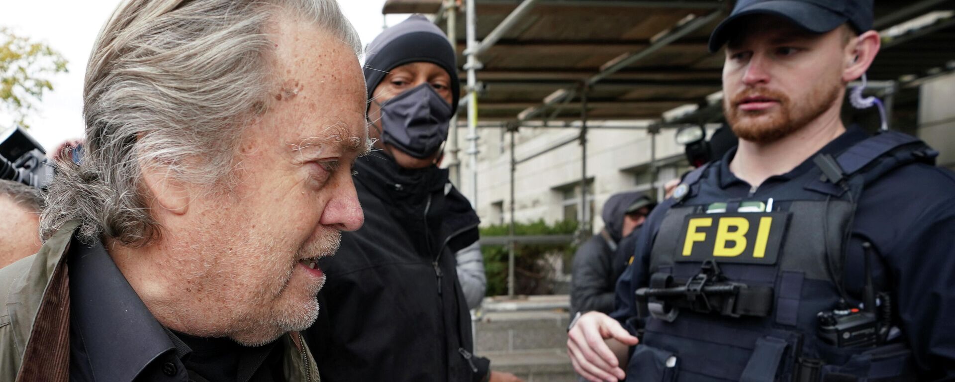 An FBI officer observes as Steve Bannon, talk show host and former White House advisor to former President Donald Trump, arrives at the FBI's Washington field office to turn himself in to federal authorities after being indicted for refusal to comply with a congressional subpoena over the January 6 attacks on the U.S. Capitol in Washington, U.S., November 15, 2021.   - Sputnik International, 1920, 15.11.2021