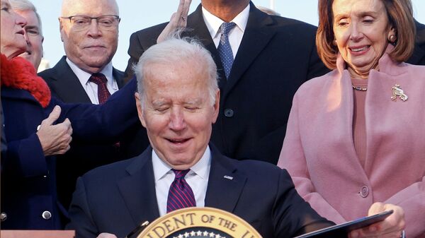U.S. President Joe Biden celebrates with lawmakers including ‪House Speaker Nancy Pelosi (D-CA) before signing the Infrastructure Investment and Jobs Act on the South Lawn at the White House in Washington, U.S. November 15, 2021. - Sputnik International