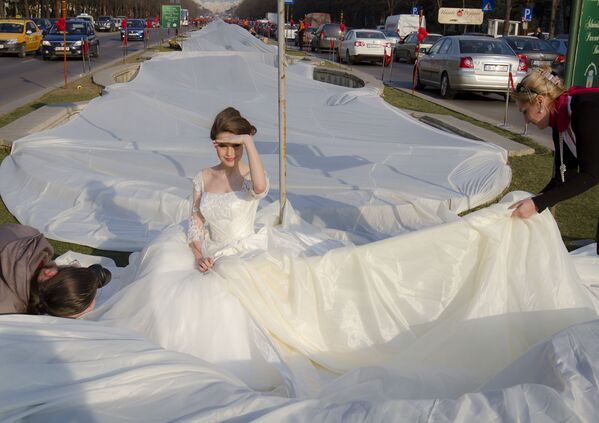Emma Dumitrescu, a 17-year- old model, poses to show the world&#x27;s longest wedding dress train during a Guinness World Record attempt in Bucharest, Romania, Tuesday, 20 March 2012.  Romania has set the world record for the world&#x27;s longest bridal train.  The nearly 3-kilometre (1.86-mile) long ivory train, which took 100 days to stitch, was showcased dramatically on Tuesday on the boulevard leading up to the giant palace built by late dictator Nicolae Ceausescu, not pictured.  The previous record was 2.488 Km. - Sputnik International