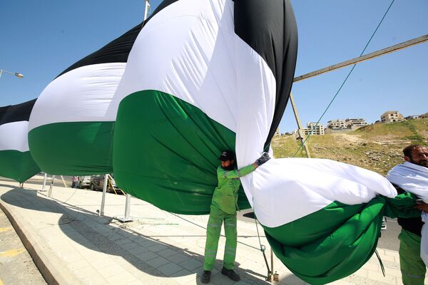 A picture shows Amman municipality workers installing a 2,132-metre long Jordanian flag aiming at breaking the Guinness world record for the world&#x27;s longest flag on 15 April 2021 in the Jordanian capital. - Sputnik International