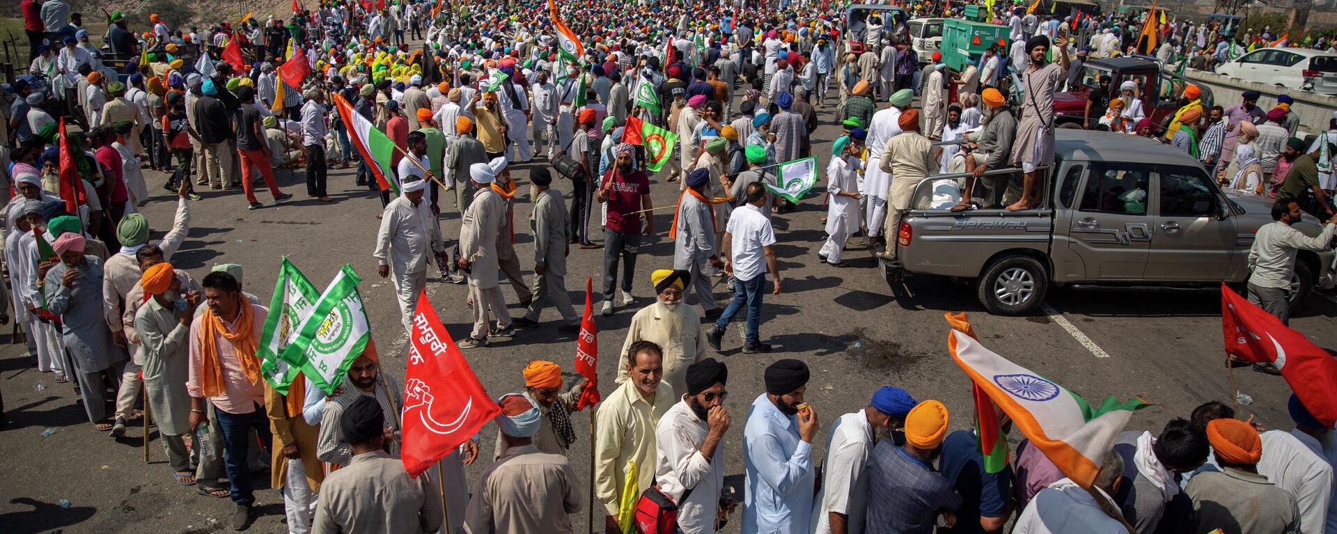 Indian farmers participate in a protest while blocking a major highway to mark 100 days of the ongoing farmer protests against new farm laws along the Delhi-Haryana border near New Delhi, India, Saturday, March 6, 2021. Thousands of farmers have hunkered down outside New Delhi’s borders since late November to voice their anger against three laws passed by Parliament last year. Prime Minister Narendra Modi’s government says the laws are necessary to modernize agriculture but farmers say they will leave them poorer and at the mercy of big corporations.  - Sputnik International, 1920, 19.11.2021