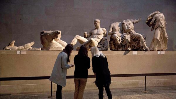Women look at a statue of the Greek god Dionysus, part of the Parthenon Marbles - Sputnik International