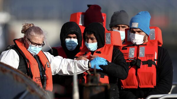 Migrants are escorted by Border Force staff into Dover harbour after crossing the channel in Dover, Britain, November 18, 2021 - Sputnik International