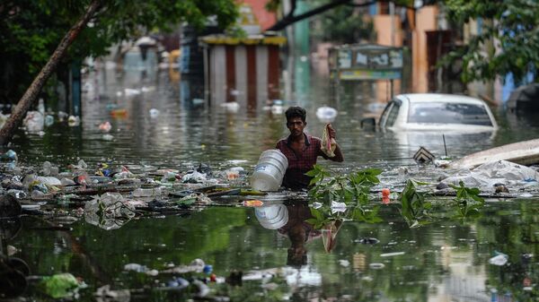 A man wades through a waterlogged street at a residential area after a heavy monsoon rainfall in Chennai on November 12, 2021. - Sputnik International